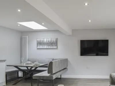 a dining room with a table and a television at Woodgate Cottage in Dalton in Furness