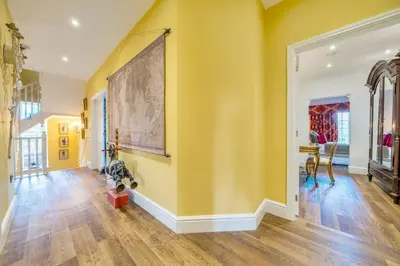 a hallway with yellow walls and a painting on the wall at Moor End Manor in Poulton le Fylde
