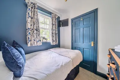 a bedroom with a bed and a blue door at Moor End Manor in Poulton le Fylde