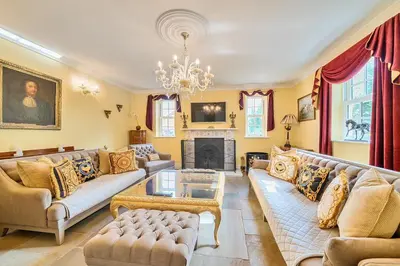 a living room with couches and a chandelier at Moor End Manor in Poulton le Fylde
