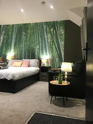 a bedroom with a bed and a large window with trees at Contemporary 1 bed studio for comfy stay in Wigan in Wigan