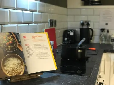 a book sitting on top of a counter in a kitchen at Contemporary 1 bed studio for comfy stay in Wigan in Wigan