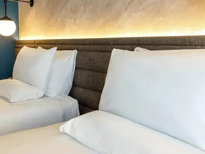two beds with white pillows in a room at Novotel Liverpool Paddington Village in Liverpool