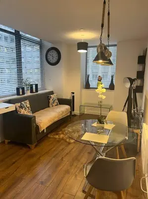 a living room with a couch and a glass table at Luxury Chic Apartments in Liverpool