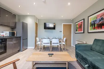 a living room with a green couch and a table at Host & Stay - The Georgian Quarters at Canning in Liverpool