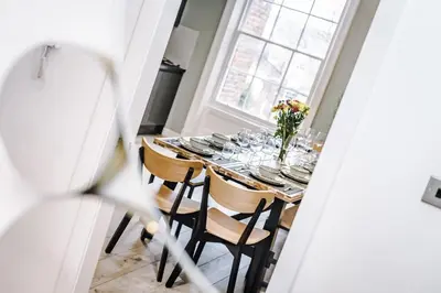 a dining room table with plates and flowers on it at Host & Stay - The Georgian Quarters at Canning in Liverpool