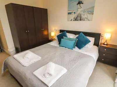 a bedroom with a large bed with two towels on it at Apartment 1 in Morecambe
