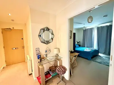 a room with a bedroom with a bed and a mirror at Apartment 1 in Morecambe