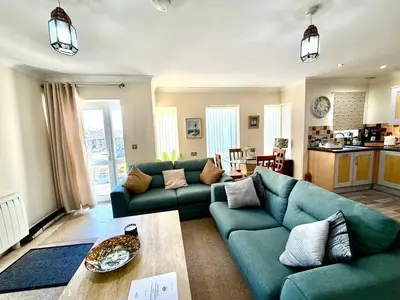 a living room with a blue couch and a table at Apartment 1 in Morecambe