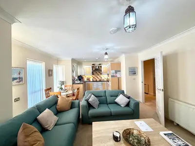 a living room with two green couches and a table at Apartment 1 in Morecambe