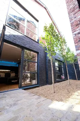 a small tree in front of a building at The Eden Warehouse - Pink Apartment (sleeps 4) in Southport