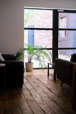 a living room with two couches and a plant at The Eden Warehouse - Pink Apartment (sleeps 4) in Southport