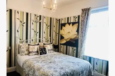 a bedroom with a bed and a painting on the wall at Dunromin Hotel in Blackpool