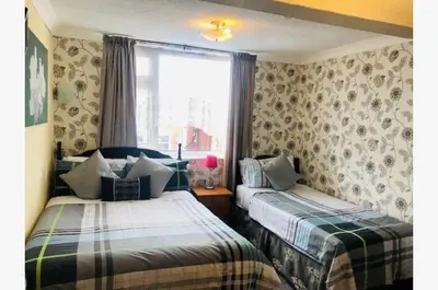 a bedroom with two beds and a window at Dunromin Hotel in Blackpool