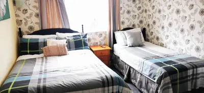 a bedroom with two beds and a window at Dunromin Hotel in Blackpool
