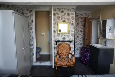 a bathroom with a chair and a sink and a toilet at Dunromin Hotel in Blackpool