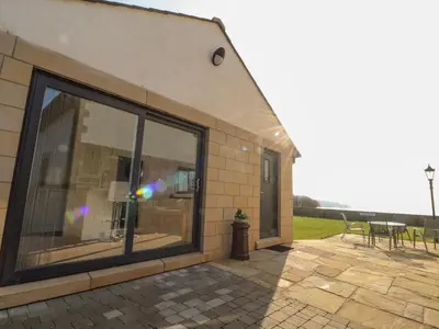 a building with a large window on a patio at 2 Bedroom Annexe in Morecambe