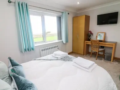 a bedroom with a bed with a desk and a window at 2 Bedroom Annexe in Morecambe