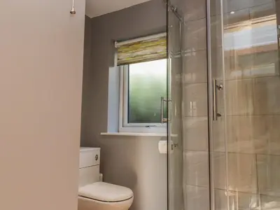 a bathroom with a toilet and a glass shower at 2 Bedroom Annexe in Morecambe