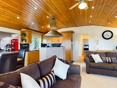 a living room with two couches and a kitchen at 3 Bedroom Lakeview Lodge - Ensuite & Balcony Deck in Carnforth