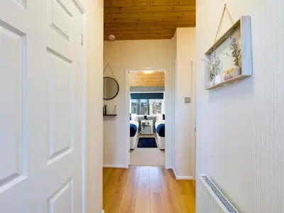 a hallway leading to a dining room with wood ceilings at 3 Bedroom Lakeview Lodge - Ensuite & Balcony Deck in Carnforth
