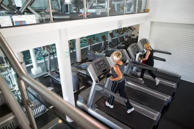 two women running on treadmills in a gym at 3 Bedroom Lakeview Lodge - Ensuite & Balcony Deck in Carnforth