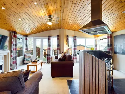 a living room with a couch and a stove at 3 Bedroom Lakeview Lodge - Ensuite & Balcony Deck in Carnforth