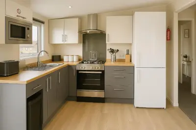 a kitchen with a stove and a refrigerator at Birch Lodge in Carnforth