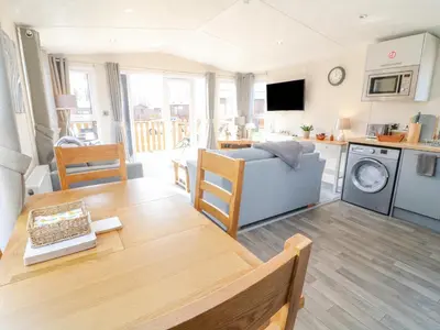 a kitchen and living room with a table and a couch at Birch Lodge in Carnforth