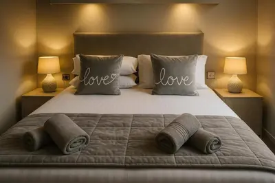 a bedroom with a bed with love pillows and two lamps at Birch Lodge in Carnforth