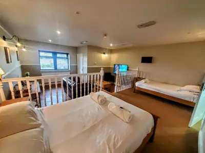 a bedroom with two beds and a living room at The Golden Ball Cottages in Morecambe