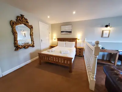 a bedroom with a bed and a mirror on the wall at The Golden Ball Cottages in Morecambe