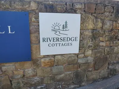 a sign for riverside coffees on a brick wall at The Golden Ball Cottages in Morecambe