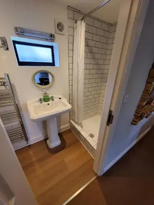 a small bathroom with a sink and a shower at The Golden Ball Cottages in Morecambe