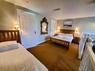 a bedroom with two beds and a mirror on the wall at The Golden Ball Cottages in Morecambe