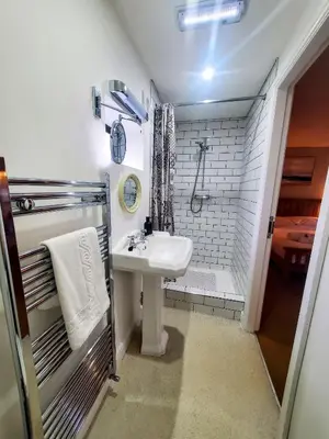 a small bathroom with a sink and a shower at The Golden Ball Cottages in Morecambe