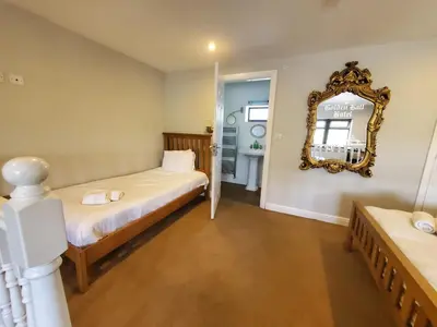 a bedroom with two beds and a mirror on the wall at The Golden Ball Cottages in Morecambe