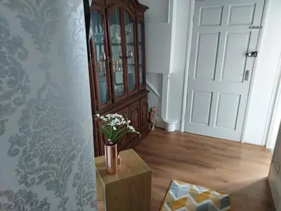 a vase of flowers on a table next to a door at 2 bed apartment 5min from sea in bare Morecombe in Morecambe