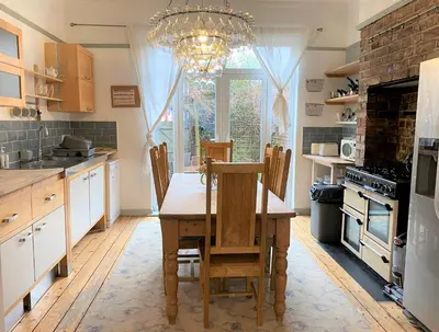 a kitchen with a table and chairs and a chandelier at Victorian Villa close to Liverpool City Centre in Liverpool