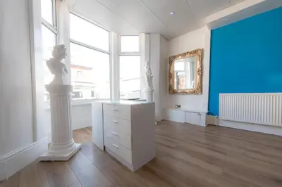 a room with a white dresser and a large window at The Adonis Hotel in Blackpool