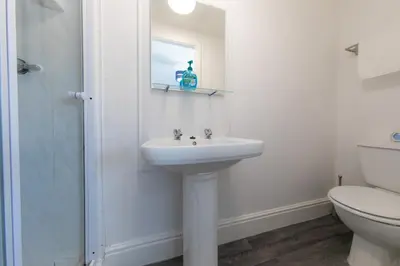 a white bathroom with a sink and a toilet at The Adonis Hotel in Blackpool