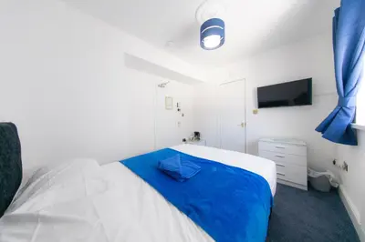 a bedroom with a bed with a blue blanket at The Adonis Hotel in Blackpool