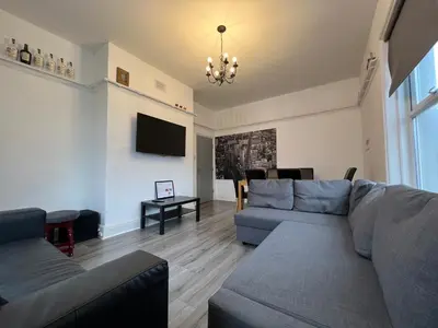 a living room with a couch and a tv at Peaky blinders apartment 5 min walk to Blackpool tower sleeps up to 14 in Blackpool