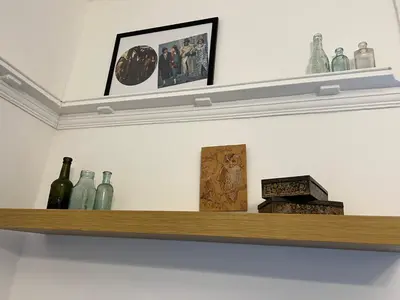 a shelf with glass bottles and a box on it at Peaky blinders apartment 5 min walk to Blackpool tower sleeps up to 14 in Blackpool