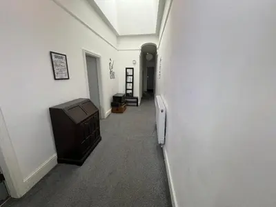 a hallway with a room with a tv and a wall at Peaky blinders apartment 5 min walk to Blackpool tower sleeps up to 14 in Blackpool