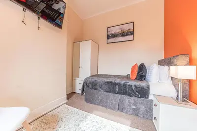 a bedroom with a bed and a desk with a lamp at *KING BED* LUXURY CITY CENTRE HOUSE in Barrow in Furness