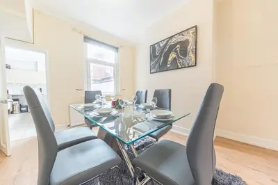a dining room with a glass table and chairs at *KING BED* LUXURY CITY CENTRE HOUSE in Barrow in Furness