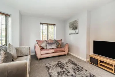 a living room with a couch and a flat screen tv at Mayfair in Wigan