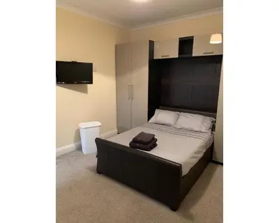 a bed with a black headboard in a bedroom at Marley Mansions Apartment - Egremont Promenade - 42 in Wallasey
