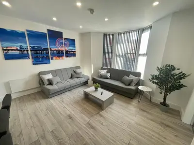 a living room with a couch and a table at Osborne hot tub and jacuzzi suites in Blackpool